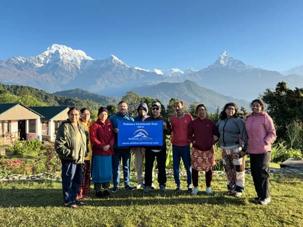 View of Machapuchare and the Annapurna range from Australian Camp surrounded by green hills.