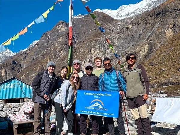 Trekkers walking along the scenic Langtang Valley trail surrounded by Himalayan peaks.